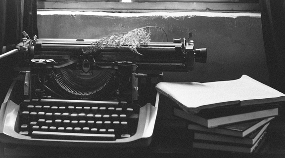 Homepage canva   grayscale photography of typewriter near books