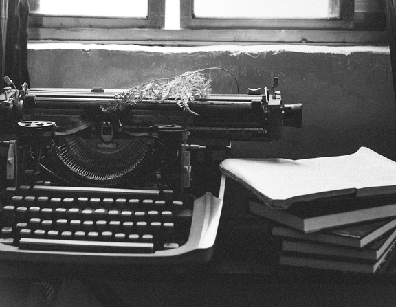 Large canva   grayscale photography of typewriter near books