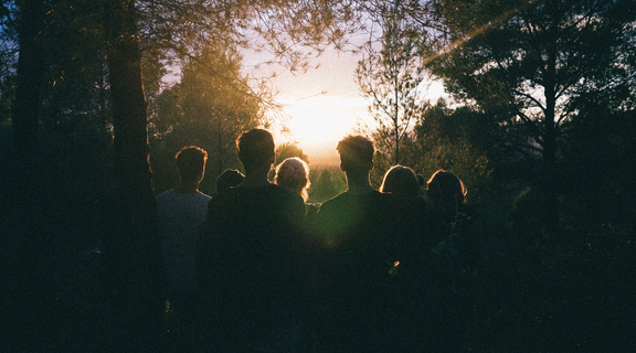 Homepage canva   silhouette of group of people between tree line